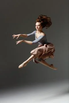 The modern dancer jumping on a gray background Stock Photos