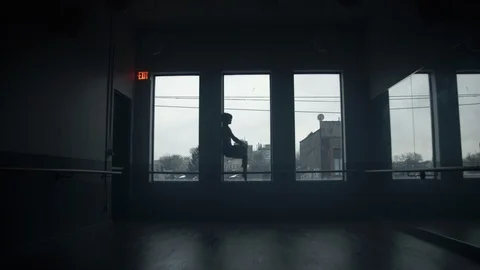 Modern dancer on window sill dancing in large dance studio 動画素材 104275800