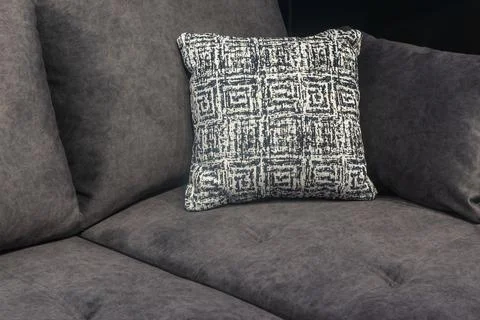 Modern dark gray fabric sofa with decorative patterned throw pillow. Close .. Stock Photos