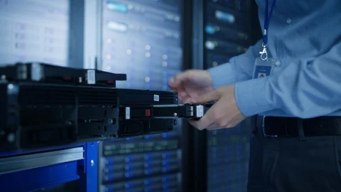 In the Modern Data Center: IT Engineer Installs New HDD Hard Drive Stockbeeldmateriaal 101183349