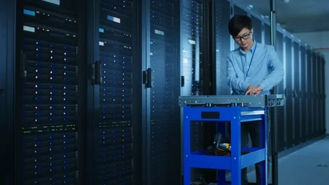 In the Modern Data Center: IT Engineer Working with Server Racks, Uses Equipment 库存影片 101684092