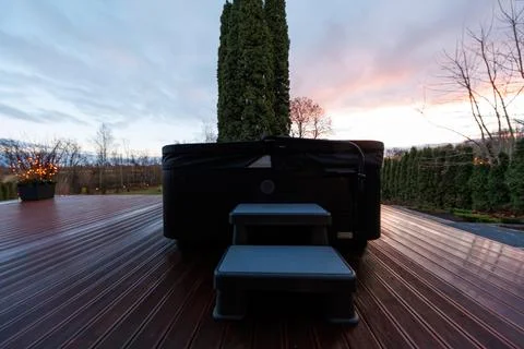 Modern deck spa at dusk with hedges and twilight reflections Stock Photos
