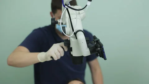 Modern dental clinic with microscope tool for treatment patients. Doctor hand in Stock Footage 194461129