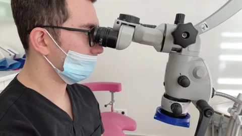 Modern dental clinic with microscope tool for treatment patients. Doctor hand in Stock Footage 230181749