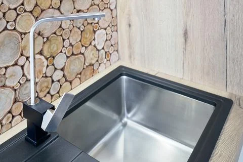 Modern design chrome rectangular section water tap closeup over stainless steel Stock Photos