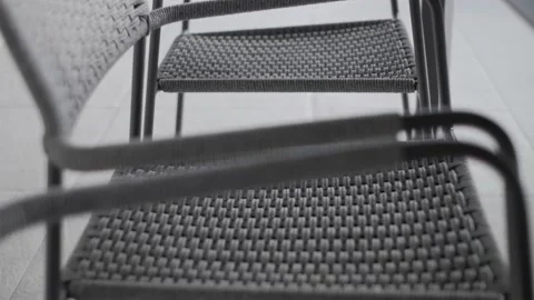 Modern designer wicker chairs stand in the courtyard on a light granite floor Stock Footage 220773656