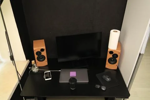 Modern desk setup with computer, speakers, and accessories for productivity Foto stock