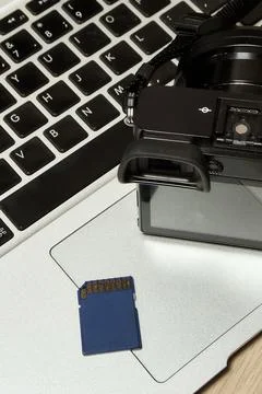 Modern digital camera, memory card and laptop, top view Stock Photos