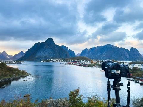 Modern digital camera on tripod capturing breathtaking sunset view of reine.. Stock-Fotos