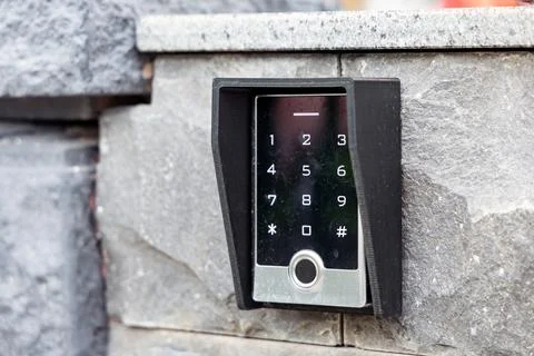 Modern digital keypad entry system mounted on stone wall with sleek design .. Stock Photos