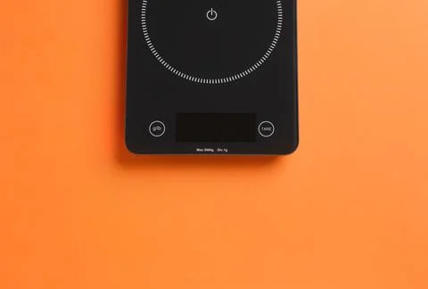 Modern digital kitchen scale on orange background, top view. Space for text Stock Photos