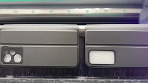 A modern digital large-format UV printer prints images on smartphone cases. Stock Footage 280437903