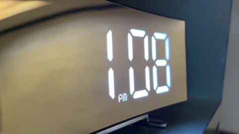 Modern digital mirror alarm clock displaying 1:08 AM with glowing LED numbers Stockbeeldmateriaal 328229616