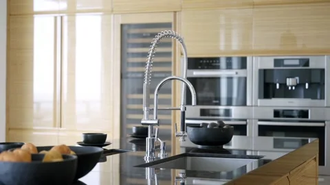 Modern dining area with glossy kitchen island from black marble, built-in sink Stock Footage 247702322