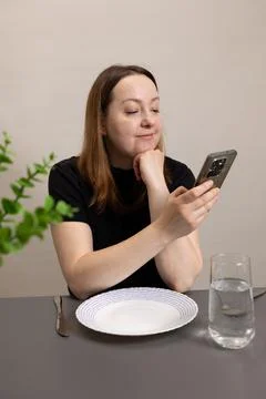 The Modern Dining Experience Exploring Smartphone Use at the Table in Todays Stock Photos