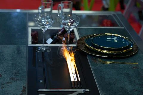 Modern dining table with fire feature and elegant tableware setup Stock Photos