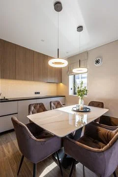 Modern dining table set with brown chairs and sleek pendant lights 写真素材