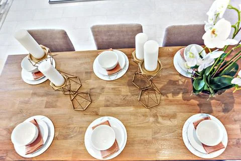 Modern dining table set up with dishes and fancy plant Stock Photos