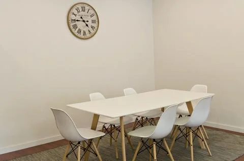 Modern dining table with six white chairs in minimalist room, clean lines Stock Photos