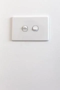 Modern double light switch on white wall with copy space - vertical image Stock Photos