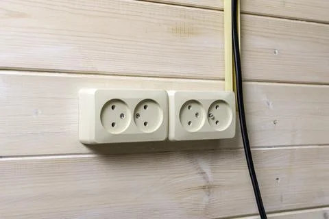 Modern double power outlets installed on light wooden wall in cozy interior, Stock Photos