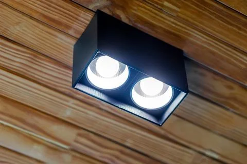 Modern dual surface-mounted LED downlight on a wooden ceiling, lighting int.. Stock Photos