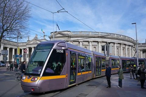 Modern Dublin tram train know as the Luas, with the old 18th century Parliame Stock Photos