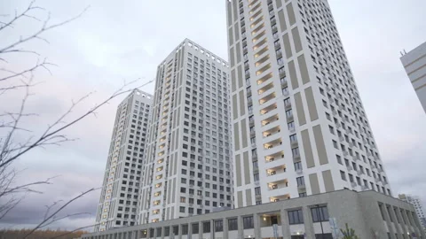 Modern dwelling skyscrapers with patterned facade under cloudy sky Vídeo Stock 304411871