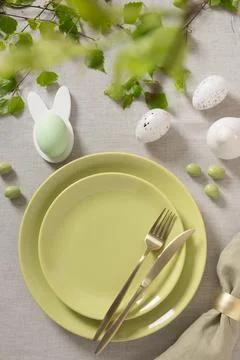 Modern Easter table setting with green plates and cutlery Stock Photos
