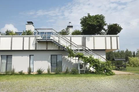 Modern eco friendly building with external metal staircase and rooftop garden Stock Photos