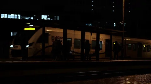 Modern electric train arrives on platform of railway station on a night dusk.. Stock-Footage 124913129