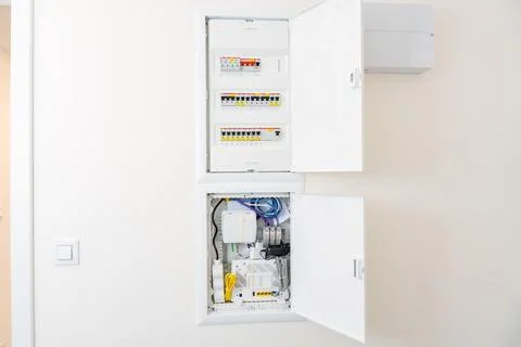 Modern electrical and network distribution panel with open doors in a smart home Stock Photos