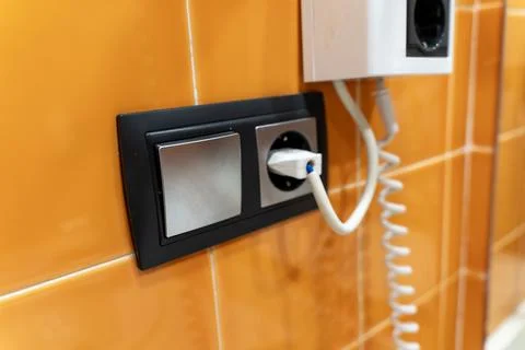 Modern Electrical Switch and Power Socket on Orange Tile Wall Stock Photos
