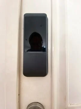 Modern electronic door lock installed on a white door, featuring a sleek design Stock Photos