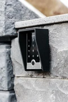 Modern electronic keypad entry system mounted on a stone wall, showcasing s.. Photos