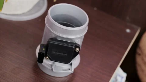 Modern electronic mass air flow sensor on brown paper, close-up. Car spare part Vídeo Stock 315512725