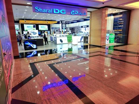 Modern electronics store interior, 'Sharaf DG,' bustling with shoppers Stock Photos