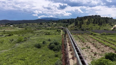 Modern elevated aqueduct stretching through a green rural landscape with Stockbeeldmateriaal 336785270