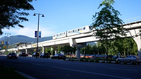 Modern Elevated SkyTrain and City Traffic with Mountain View Background 스톡 동영상 339099351