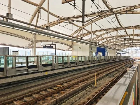 Modern Elevated Train Station Platform and Railway Tracks Under Canopy 库存照片