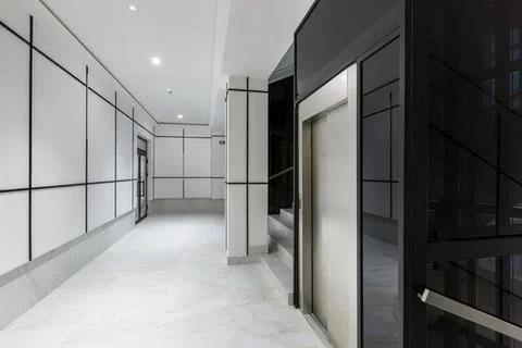 Modern elevator in bright building corridor with clean design Stock Photos