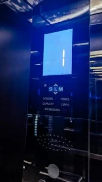 A modern elevator control panel with a digital display. The panel shows the Stock Photos