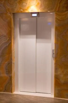 Modern elevator doors in hotel or office building interior Stock Photos