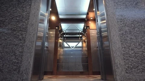 Modern elevator opening and closing loop in office lobby Stock Footage 337946895
