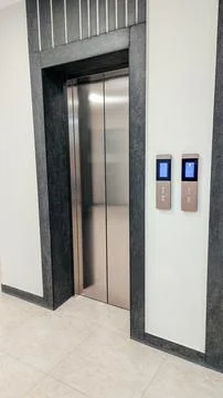 A modern elevator with stainless steel doors in a contemporary building. The Stock Photos