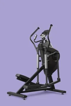 Modern elliptical machine on lilac background Stock Photos