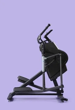 Modern elliptical machine on lilac background Stock Photos