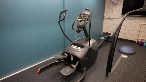 Modern elliptical trainer machine in indoor cardio fitness studio Video stock 330627261