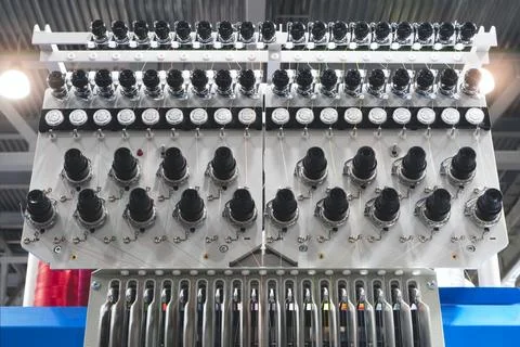 Modern embroidery machines with spools of thread. Bright orange and gray thre 스톡 사진