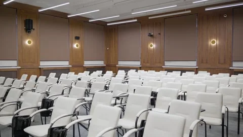 Modern empty classroom, lecture hall, with white chairs and brown walls Stock Footage 302473582